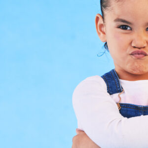 Kind mit verschränkten Armen und trotziger Mimik als Symbol für herausforderndes Verhalten - Impulsvortrag Lebenshilfe Alfeld