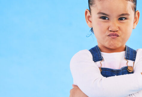 Kind mit verschränkten Armen und trotziger Mimik als Symbol für herausforderndes Verhalten - Impulsvortrag Lebenshilfe Alfeld