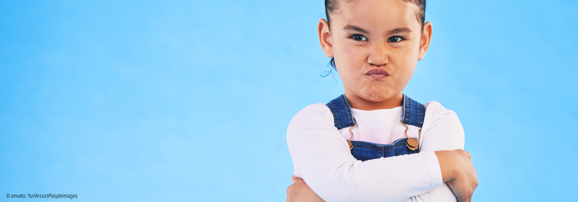 Kind mit verschränkten Armen und trotziger Mimik als Symbol für herausforderndes Verhalten - Impulsvortrag Lebenshilfe Alfeld