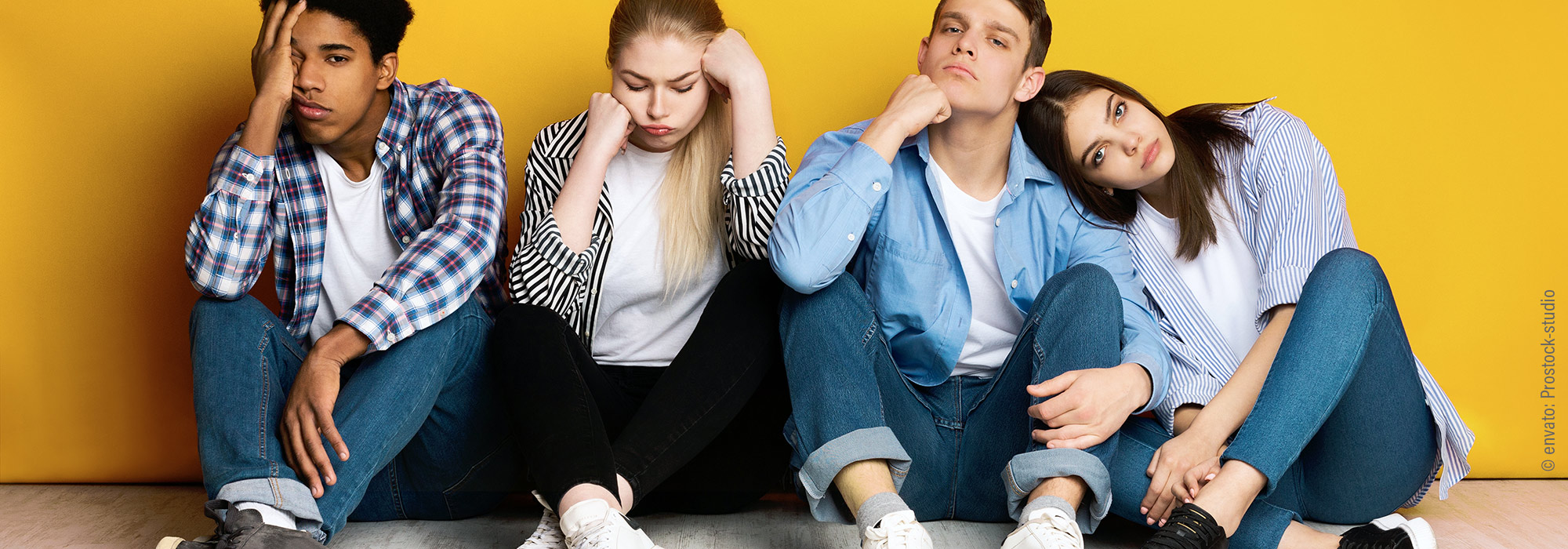 Vier Jugendliche in unterschiedlichen Gemütszuständen sitzen an gelber Wand - NEBI Impulsvortrag – Kommunikation & Beziehungsgestaltung Schüler Autismus Spektrum