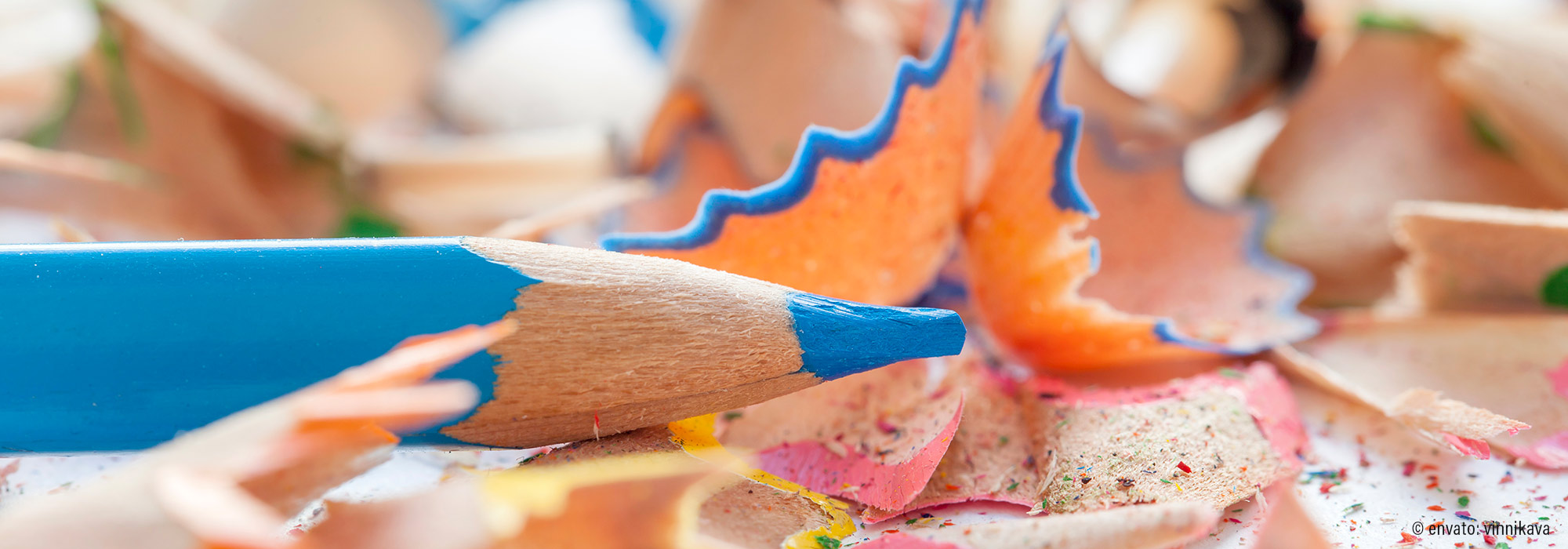 Blauer Buntstift in Nahaufnahme mit bunten Spitzspänen beim Malen - Heilpädagogischer Workshop Lass uns kritzeln kreative Förderung Lebenshilfe